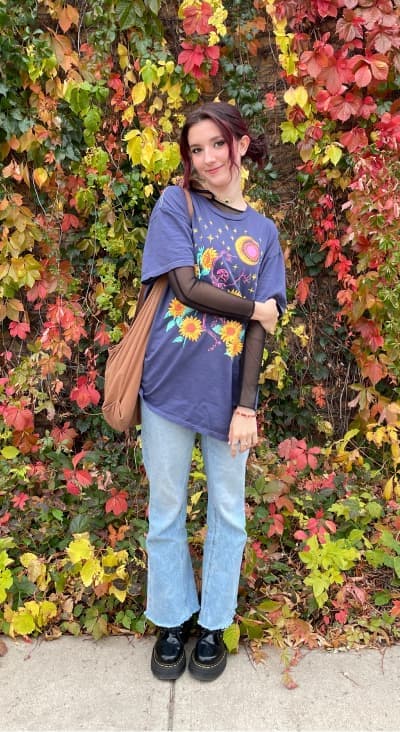 Cassie standing in front of wall with fall leaves